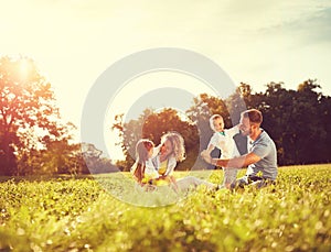 Male and female playing with children outside photo