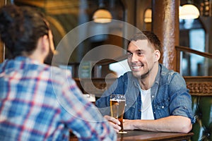 Happy male friends drinking beer at bar or pub