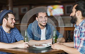 Happy male friends drinking beer at bar or pub