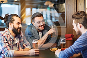 Happy male friends drinking beer at bar or pub