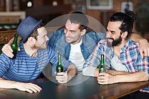 Happy male friends drinking beer at bar or pub