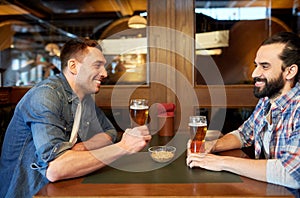 Happy male friends drinking beer at bar or pub