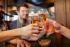 Happy male friends drinking beer at bar or pub