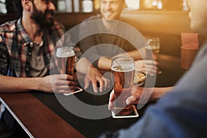 Happy male friends drinking beer at bar or pub