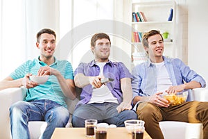 Happy male friends watching tv at home