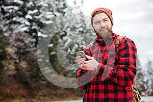 Happy male hiker using smartphone