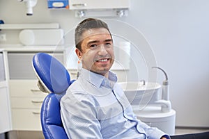 Happy male patient sitting on dental chair