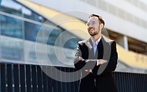 Happy male portrait in suit on background of skyscraper. Good prospects and early career