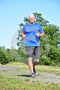 Happy Male Senior Jogging In Park