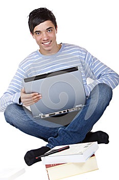 Happy male student sitting with laptop on floor