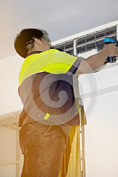 Happy Male Technician Repairing Air Conditioner