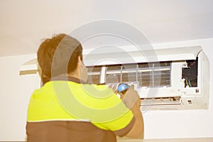 Happy Male Technician Repairing Air Conditioner