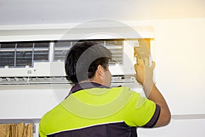 Happy Male Technician Repairing Air Conditioner