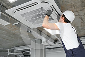 Happy Male Technician Repairing Air Conditioner