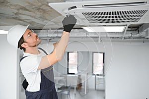 Happy Male Technician Repairing Air Conditioner