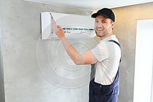 Happy Male Technician Repairing Air Conditioner.