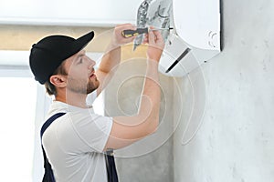 Happy Male Technician Repairing Air Conditioner.