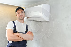 Happy Male Technician Repairing Air Conditioner.