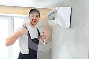 Happy Male Technician Repairing Air Conditioner.