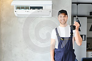 Happy Male Technician Repairing Air Conditioner.