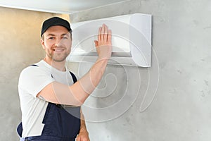 Happy Male Technician Repairing Air Conditioner.