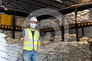 Happy a male warehouse worker portrait with laptop in alum or chemical warehouse storage. International export business concept