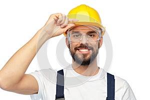 Happy male worker or builder in helmet and overall
