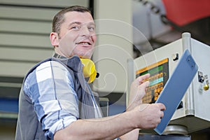 happy male worker operating machine