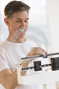 Happy Man Adjusting Balance Weight Scale