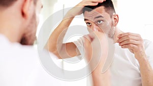 Happy man applying hair styler at bathroom