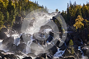 Happy man with backpack enjoying amazing waterfall Travel Lifestyle and success concept vacations into the wild nature