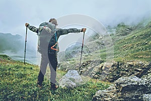Happy Man backpacker hiking in foggy mountains photo