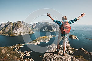 Happy Man backpacker raised hands on mountain top