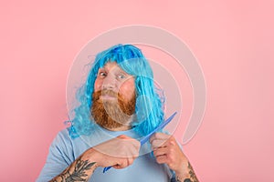 Happy man with beard and blue peruke combs her hair like a woman
