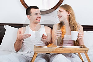 Happy man and beautiful girlfriend with tasty breakfast
