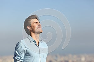 Happy man breathing deeply fresh air outskirts