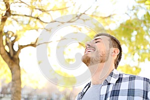 Happy man is breathing fresh air in a park