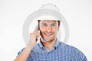 Happy man building engineer in helmet talking on mobile phone