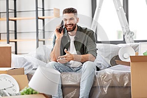 happy man calling on smartphone moving to new home