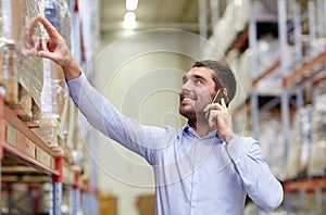 Happy man calling on smartphone at warehouse