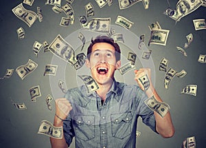 Happy man celebrates success under money rain