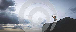 Happy man celebrating success on the peak of mountain