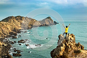 A Happy Man Celebrating Victory on The Top of Mountain by The Ocean