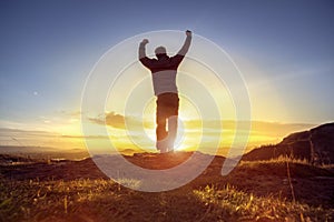 Happy man celebrating winning success against sunset