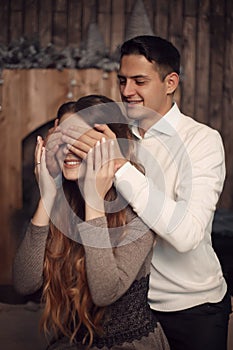 Happy Man covering woman`s eyes with his hands. Surprised girl i