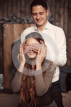 Happy Man covering woman`s eyes with his hands. Surprised girl i