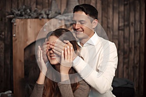 Happy Man covering woman`s eyes with his hands. Surprised girl i