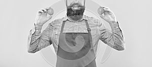 Happy man crop view in red apron holding fresh limes citrus fruits yellow background, fruiterer photo