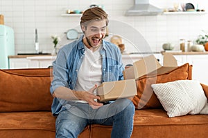 Happy man customer unpacking cardboard box receive open post mail delivery package