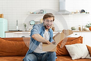 Happy man customer unpacking cardboard box receive open post mail delivery package